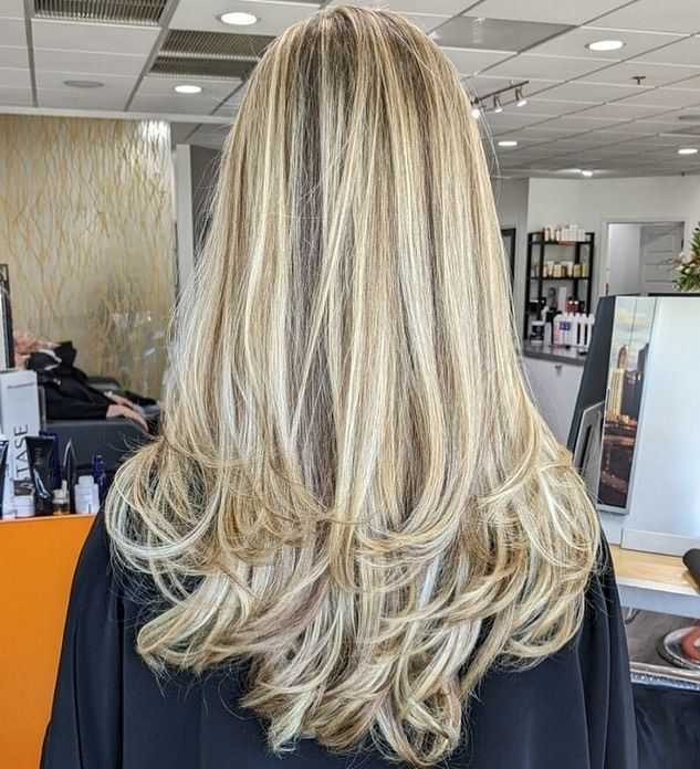 Medium-length blonde hair with soft curls, styled in a salon setting.